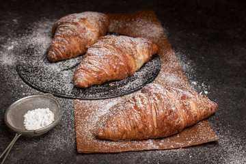 fresh croissants on a dark board, top view