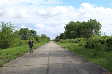Fototapeta premium Man walking on an abandoned road at Midewin National Tallgrass Prairie
