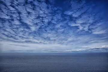 Obraz premium sky above water / texture background, horizon sky with clouds on the lake
