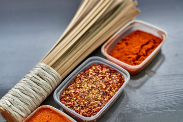 Spices in plastic containers with bamboo brush