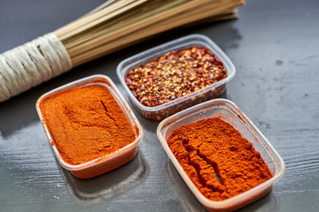 Spices in plastic containers with bamboo brush