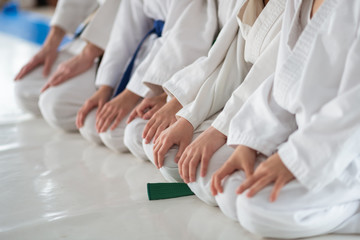 Children sitting on floor and listening to trainer