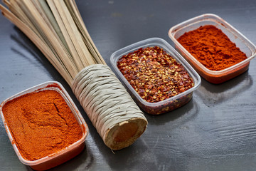 Spices in plastic containers with bamboo brush