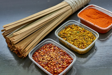 Spices in plastic containers with bamboo brush