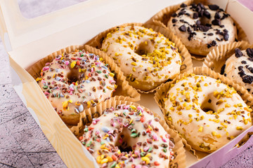 Draufsicht von geschmackvollen glasierten bunten Schaumgummiringen auf hellem rosa Hintergrund