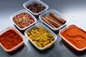 Spices in plastic containers with bamboo brush