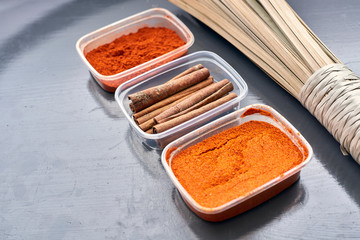 Spices in plastic containers with bamboo brush