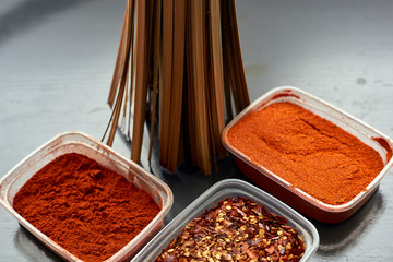 Spices in plastic containers with bamboo brush