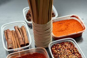 Spices in plastic containers with bamboo brush