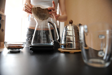 Barista girl brews coffee in an unusual coconut shell purover coconut shell