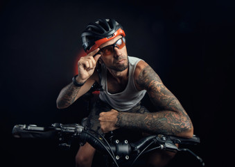 Fototapeta premium guy in a Bicycle helmet emotionally posing on a black background