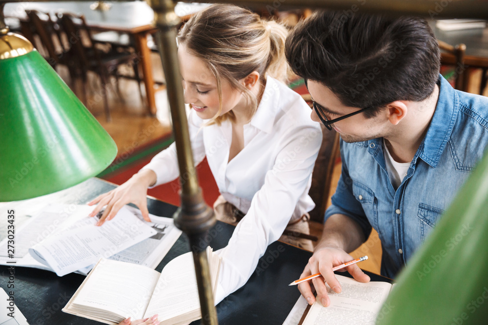 Canvas Prints Smart cheerful teenagers studying at the library together