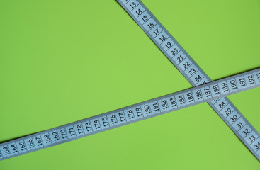 Blue measuring tape on green background with black numbers.