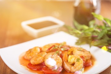 Delicious cooked shrimps with tomatoes on white plate