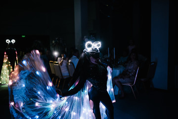 People in glowing costumes dancing in the dark