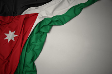 waving national flag of jordan on a gray background.