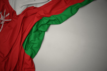 waving national flag of oman on a gray background. - obrazy, fototapety, plakaty
