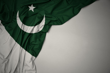 waving national flag of pakistan on a gray background. - obrazy, fototapety, plakaty
