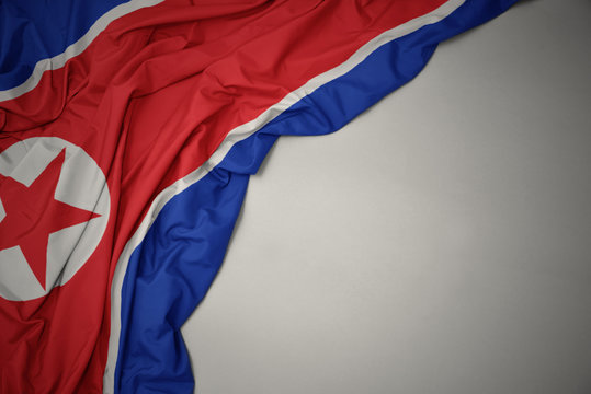 waving national flag of north korea on a gray background.