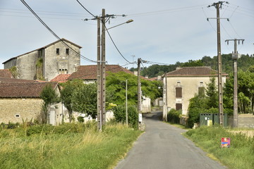 Fototapeta na wymiar L'entrée du Bourg de Champagne et le clocher de son église romane 