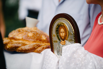 The bride at the wedding ceremony in the church holding an icon