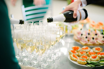 Man pours champagne into a glass from a bottle