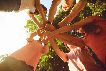 Friends hold hands in the park in the summer.