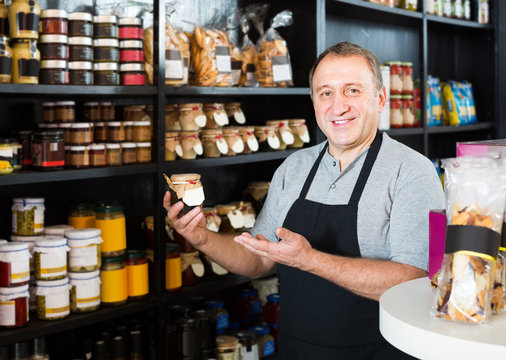 salesman working in delicatessen section of ordinary grocery