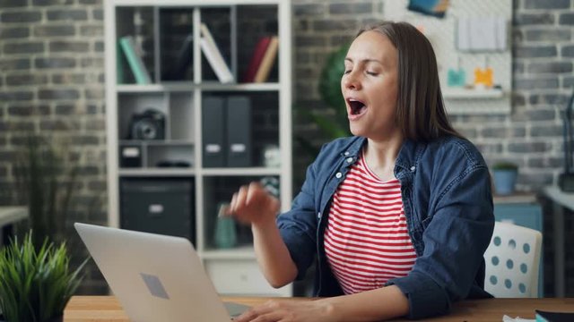 Tired office manager attractive girl is yawning stretching body feeling unhappy and exhausted at work. Overwork, busy millennials and deadline concept.