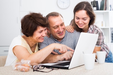 Fototapeta premium senior couple and daughter with laptop at home.