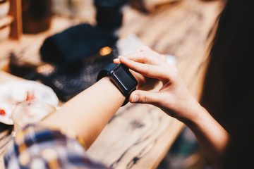 Women hand wear smart watch sitting in cafe