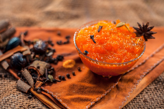 Famous Indian dessert and sweet dish in a glass bowl on jute bag's surface i.e. Murabba or Murba along with entire constituents of it on the surface.Made of Mango.Horizontal shot with only spices.