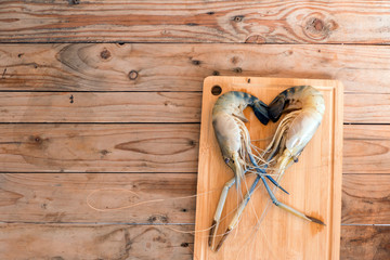 Big prawns on the wooden chopping board on the wooden table