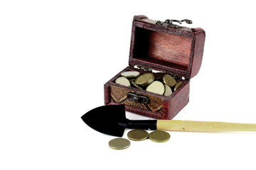 A small chest of wood with coins on a light background.