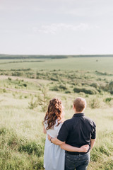 young couple man and woman look together into the green distance