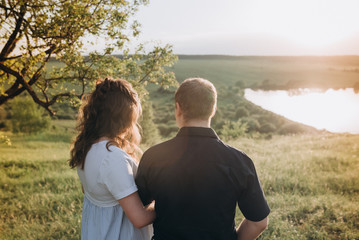 young couple man and woman look together into the green distance