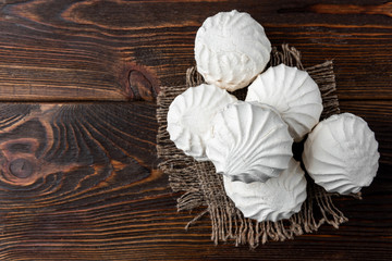 White marshmallow on dark wooden background.