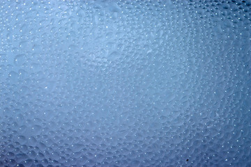 Drops of condensate on the surface of a plastic bottle, close-up