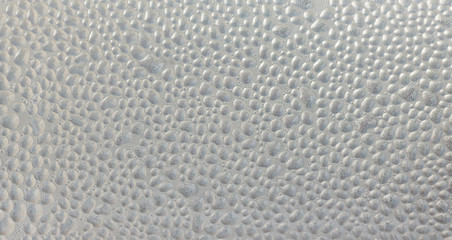 Drops of condensate on the surface of a plastic bottle, close-up
