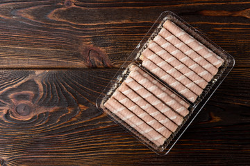 Sweet chocolate waffle rolls on dark wooden background.