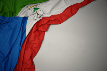 waving national flag of equatorial guinea on a gray background.
