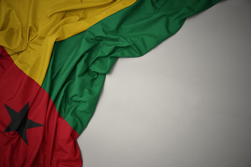 waving national flag of guinea bissau on a gray background.
