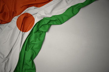 waving national flag of niger on a gray background. - obrazy, fototapety, plakaty