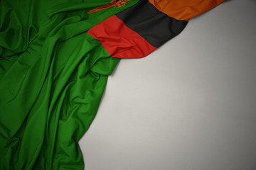 waving national flag of zambia on a gray background.