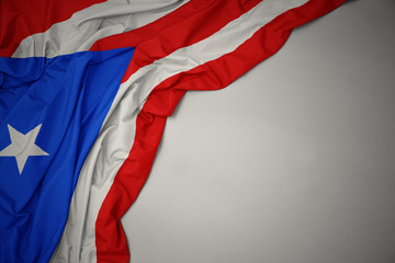 waving national flag of puerto rico on a gray background.