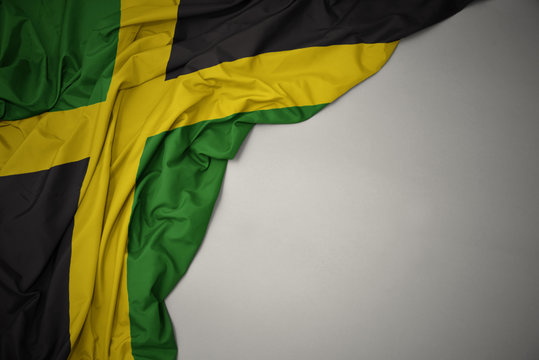 waving national flag of jamaica on a gray background.
