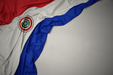 waving national flag of paraguay on a gray background. - obrazy, fototapety, plakaty