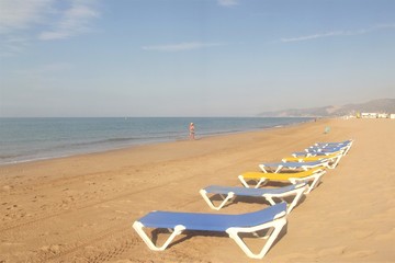 Loungers at the water's edge on a desert beach
