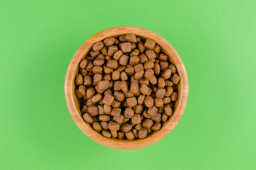 dog food in a bowl on green background, flat lay