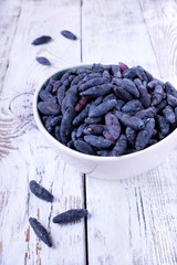 Fresh honeysuckles in a white bowl on wooden table